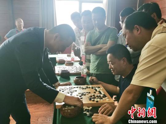 图为古力、常昊同时与22位来自全国各地的围棋爱好者进行“车轮战”指导棋现场。　胡腾 摄