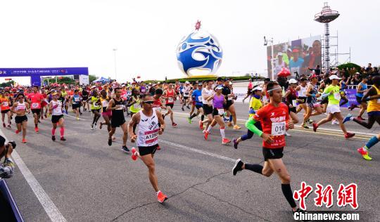 虽然天气炎热，依然有人选择是室外跑步。(资料图：6月16日，海阳国际马拉松鸣枪起跑。　徐勇 摄)