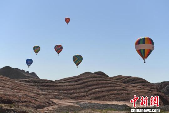 图为热气球与七彩丹霞的唯美邂逅。　杨艳敏 摄